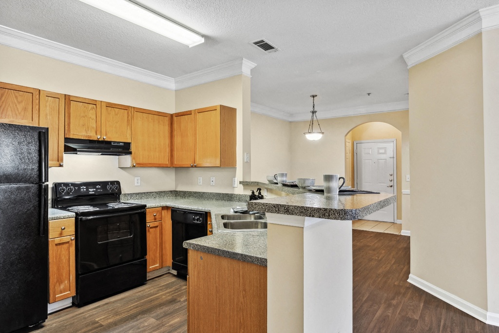 A kitchen with hardwood floors at the Longwood Vista Apartments in Atlanta, Georgia.